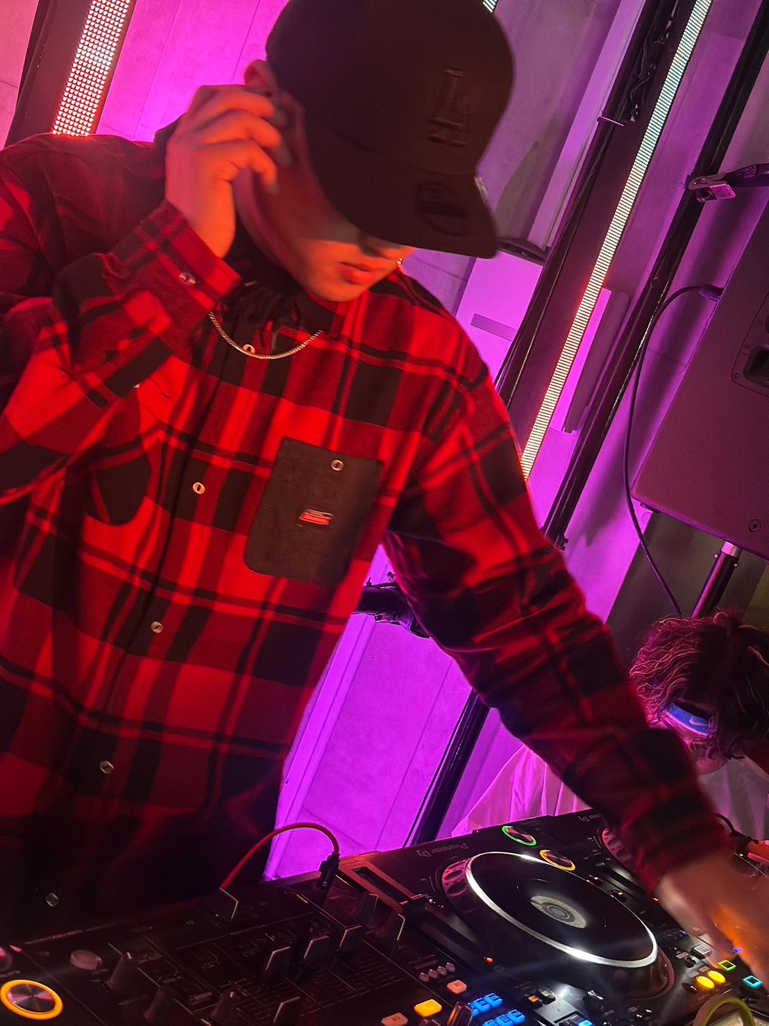 赤いチェックのシャツを着てDJをするOROCHIさん
